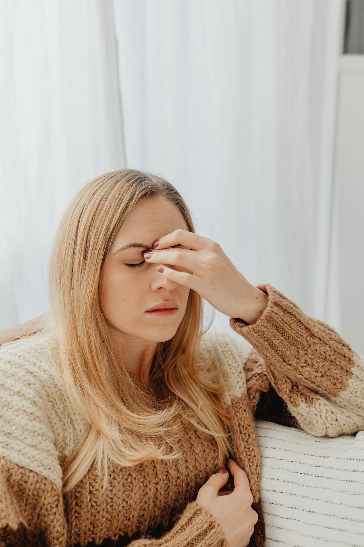 Woman holding her face from sinus pressure, related to ent reno care for allergy symptoms